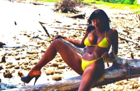 Ebony beauty Marguerite Martin models a yellow bikini during an outdoor gig