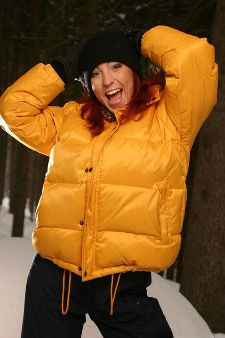 Redheaded girl strips to her underwear while in a snowy forest