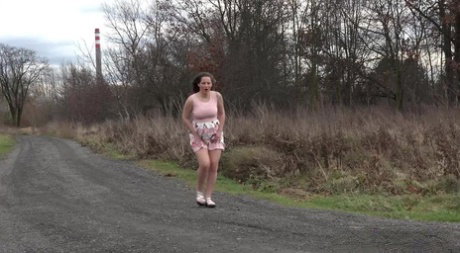Caucasian girl Nicolette Noir takes a big piss on a dirt road in the country