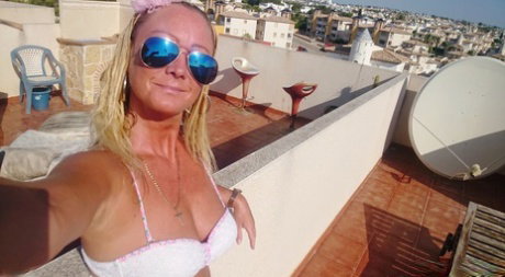 Naughty mature blonde Natalie K shows her big tits & her shaved pussy outdoors