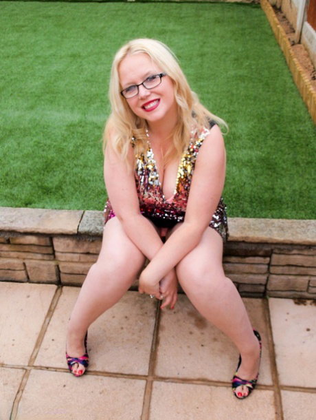 Overweight UK blonde Sindy Bust gets naked on a retaining wall in a backyard