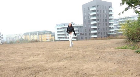 Pretty brunette Maddi Black pulls down her pants to piss in a wide open lot