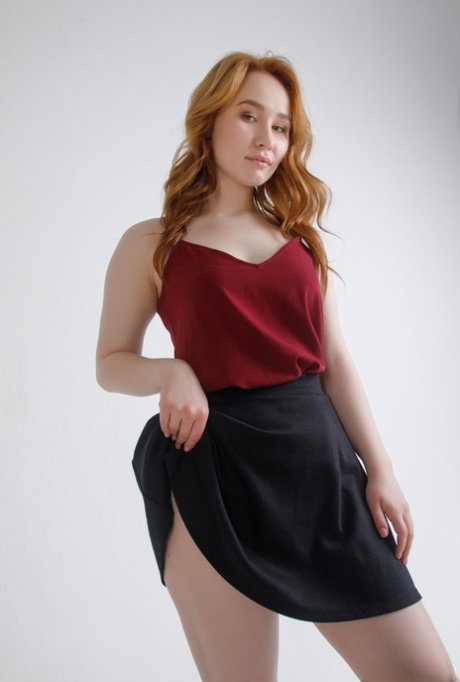 Young redhead Vanessa Mei reveals her trimmed muff while getting bare naked