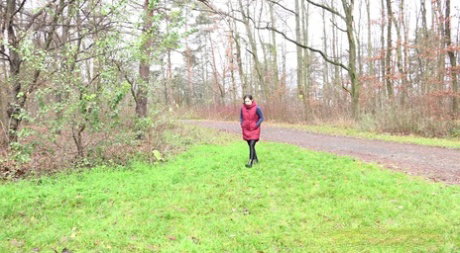 Lara Fox pulls down her pants to pee on a bench beside a path in the woods