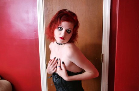 Redheaded goth Teen Satine releases her small tits from a corset