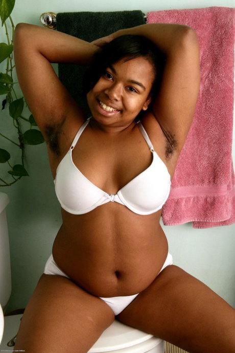 Chubby ebony girl Monica Jimenez gets naked on a toilet seat in her bathroom