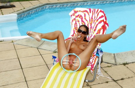 Desirable teenage hottie toying her shaved cunt by the pool
