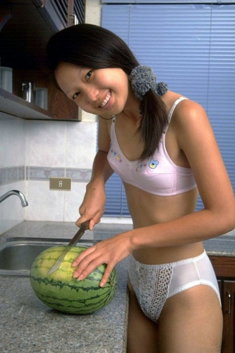 Charming Asian teen removes lace underwear while eating a watermelon