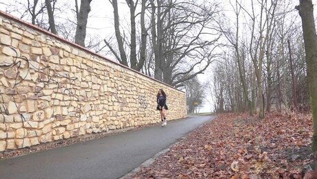 Mini Mitzi squats against a stone wall to take a badly needed piss