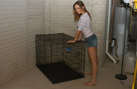 Amateur girl Nikki Sims strips to her pretties inside a dog cage