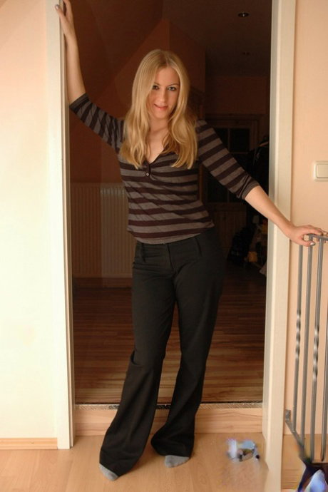 Blonde amateur Kiss Kristin goes topless in a doorway at home