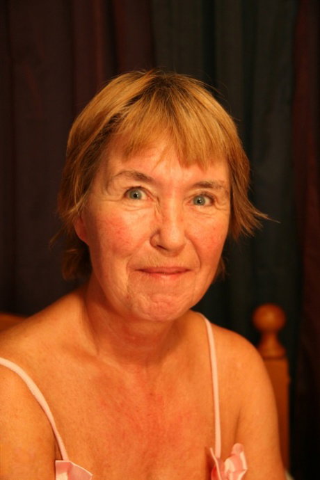Short-haired granny Loesje masturbating in her sexy outfits in a solo