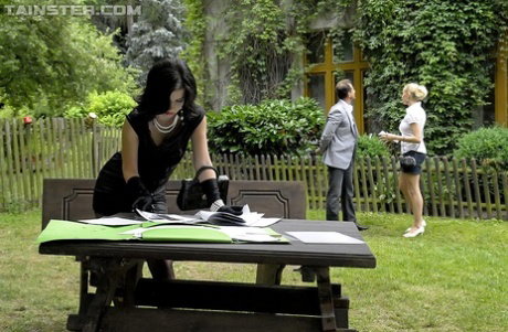 2 fully clothed dames suck off a man on picnic table in back yard