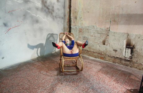 Punky blonde in rope restraints and a ball gag endures a masturbation session