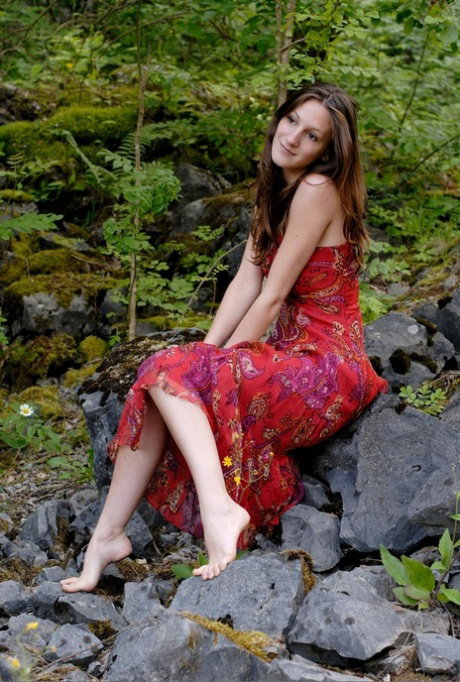 Long legged white girl with firm boobs models naked in the middle of the woods