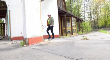 Caucasian girl Chloe Lamour pees on paved ground outside of a building