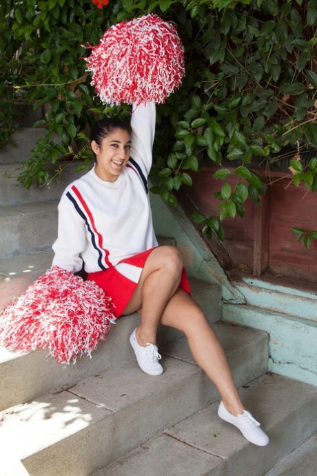 Cute brunette cheerleader Leila presents her wet muff outdoors in solo
