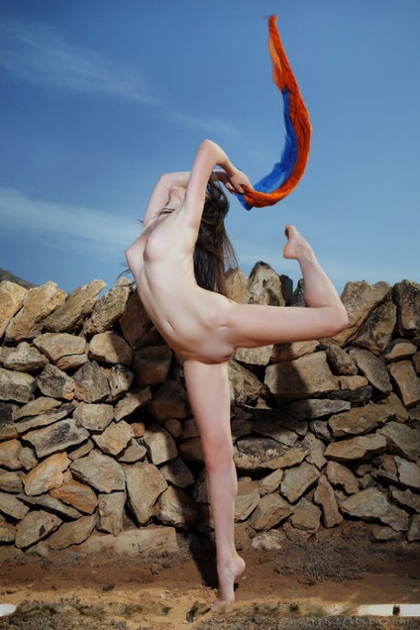 Naked teen Serena Wood strikes great solo poses by a dry stacked stone wall