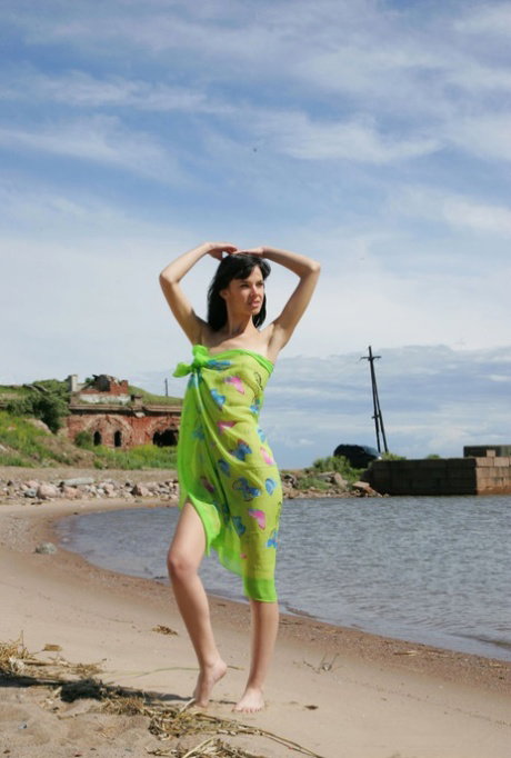 Long legged 18 year old gets naked on a beach in a playful manner