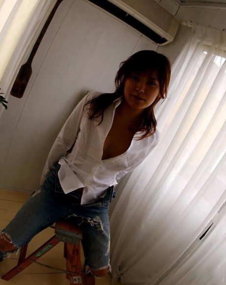 Hot Japanese teen with a phat ass Kana partially disrobes on a loveseat