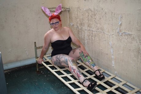 Tattooed redhead Mollie Foxxx models in a bunny costume and glasses