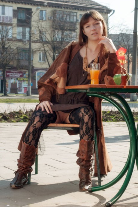 Long haired teen Red Eva exposes her tits and twat in a public square