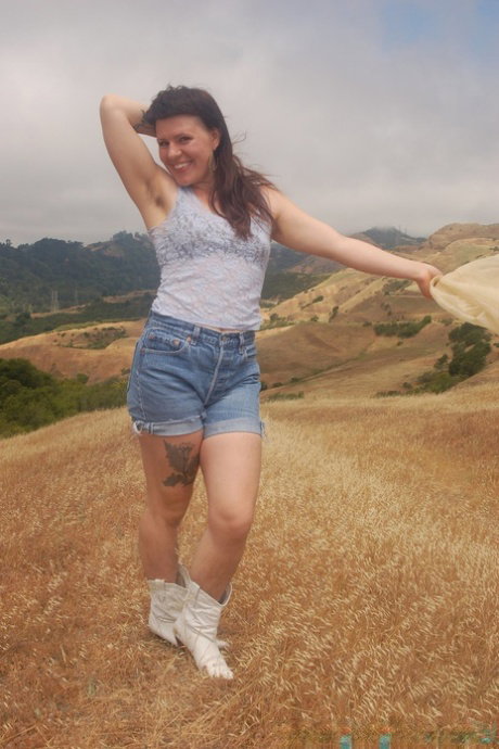 Petite amateur Olivia Rose shows her naturals and hairy pussy in a field