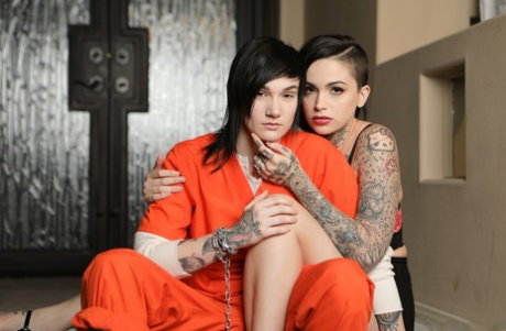 Tattooed lesbians Nikki Hearts and Leigh Raven have sex on a sofa