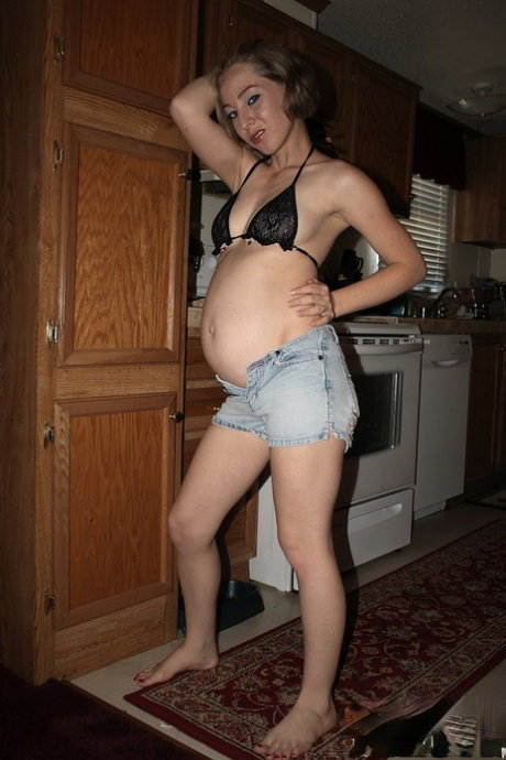 Heavily pregnant girl doffs bikini top and denim shorts to model totally naked