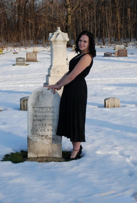 Amateur chick Emily Love exposes her tits in the graveyard during the winter