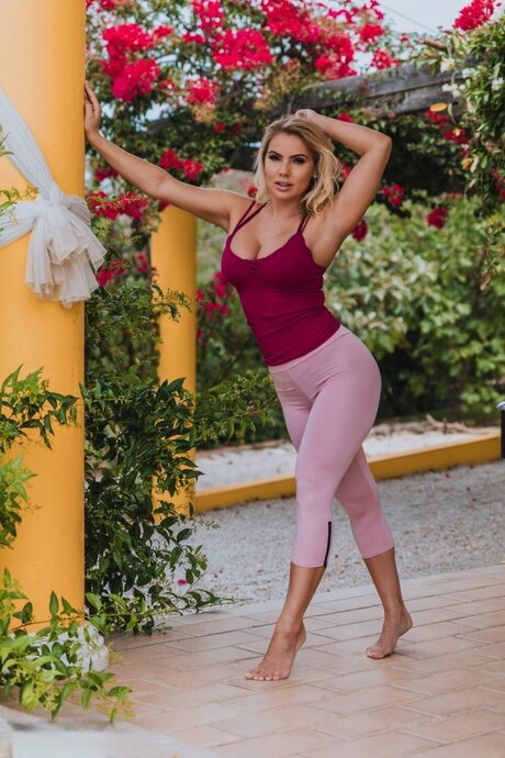 Blonde British girl Electra Morgan uncovers her fake tits while wearing a thong