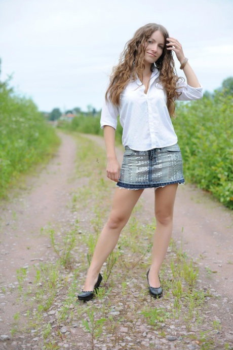 Sweet petite babe Ekitti lets out her big tits and poses outdoors in a solo