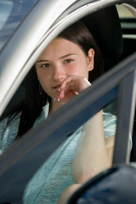 Cute brunette teen Matty reveals her bum and shaved pussy in a car