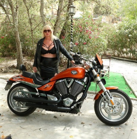Mature blonde Melody uncovers her large breasts atop a motorcycle
