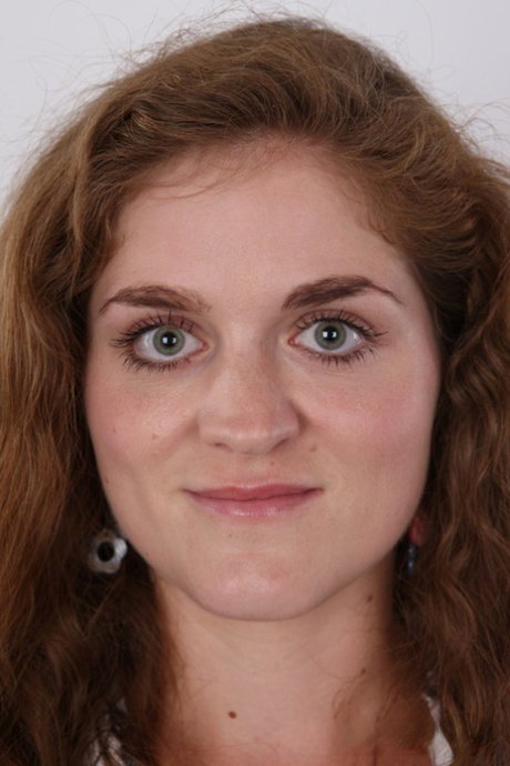 Natural redhead stands naked with her clothes and shoes removed