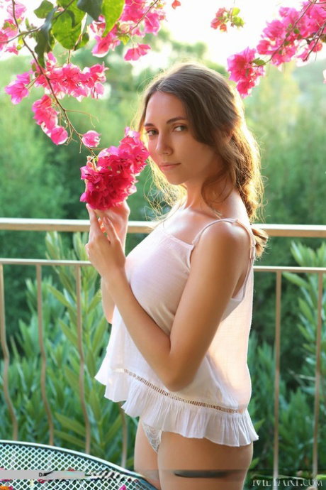 Busty teen Danniela gets completely naked on a balcony during solo action