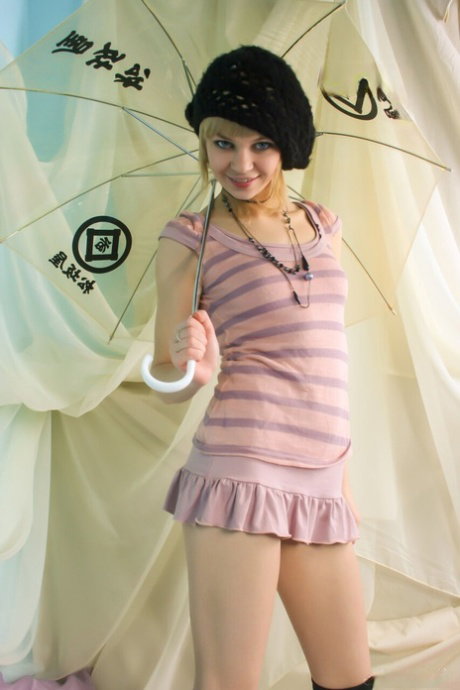Amateur model uncups her tiny tits before removing striped OTK socks