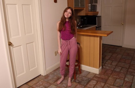Young redhead Myra Glasford gets naked to masturbate on a kitchen counter
