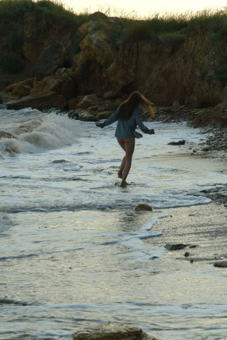 Nice teen girl Petra E removes her shirt after wading out into the ocean