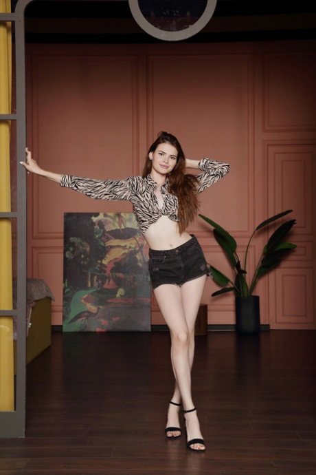 Pale redhead with long legs tugs on her labia lips after getting naked