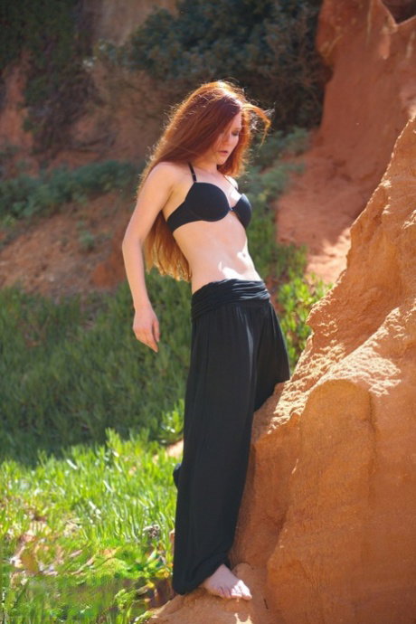 Natural redhead Mia Sollis strikes a yoga pose while getting naked in nature