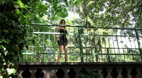 Leggy chick Rebecca squats for a pee while on a pedestrian bridge
