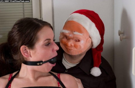Creepy man in a Santa mask ball gags and ties up a clothed brunette