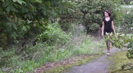 Short taken girl Kristina pulls her hose down for a piss on a pathway