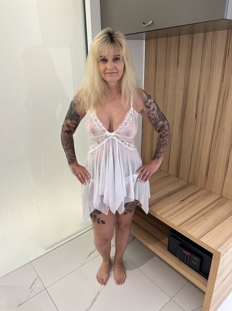 Tattooed blonde amateur displays her big tits and big ass in the nude