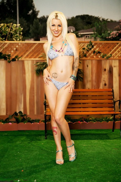 Sexy blonde Stevie Shae models a bikini while in a backyard location