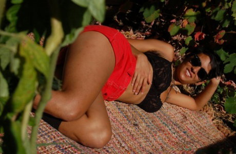 American Sonya undresses in the garden & flaunts her big tits and fuzzy twat