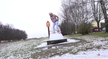 Blonde girl Licky Lex takes a pee on a snow-covered slide at a park