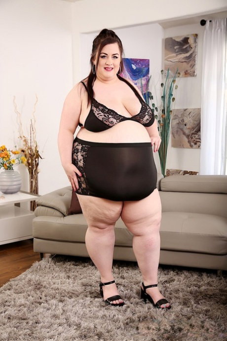 Brunette SSBBW Ashley Garland finger spreads her pussy on a sofa in heels