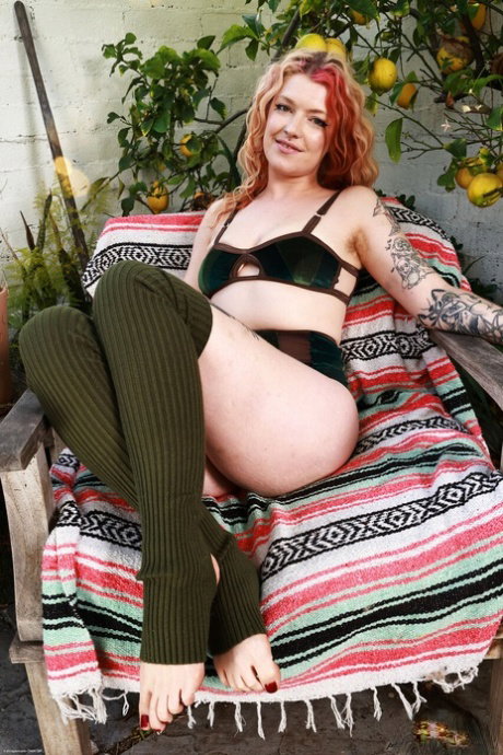 Tattooed redhead Apricot Pitts spreads her hairy pussy after getting naked